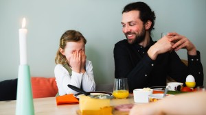 En kvinne og mann sitter ute i hagen og smiler og snakker sammen