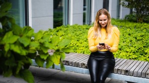 Kvinna som sitter utomhus på en bänk