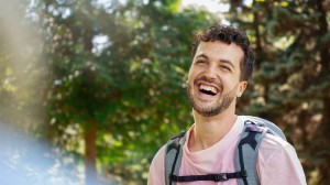 Mann er ute i naturen og smiler stort