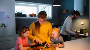 En hyggelig stund på kjøkkenet med en mor som lager mat mens barna ser på