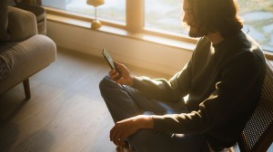 Man som sitter i en fåtölj med sin mobiltelefon