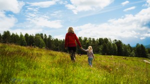 Mor och dotter som går över en äng