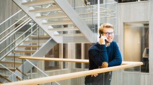 En mann står og holder en mobiltelefon inntil øret