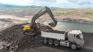 Volvo gravemaskin som laster stein i en Volvo dumper i et stenbrudd.