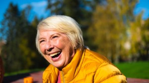 Eldre kvinne som ler og er glad.