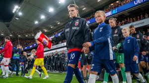 Landslagsmaskot går hånd i hånd med Martin Ødegaard ut på fotballbane