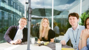 Fire summer interns sitter rundt et bord på kontoret