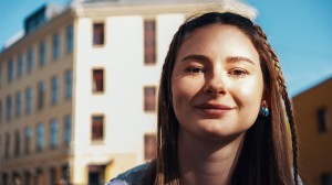 En ung kvinne smiler mot kamera.