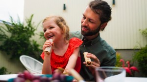 Pappa och dotter som äter tunnbrödsrulle