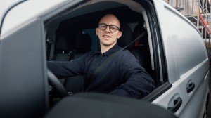 En arbeidsmann i forsetet av en firmabil.