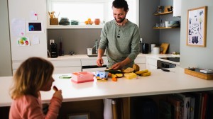 To barn sitter i sofaen og holder i hver sin mobiltelefon