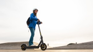 Ung tjej med hjälm på elsparkcykel