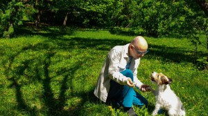Mann lærer opp hunden sin til å gi labb