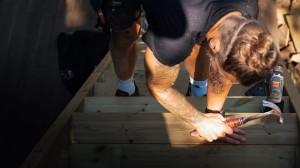 A carpenter building a set of stairs in the sun