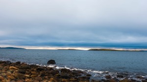 Stenstrand, hav och mörk himmel