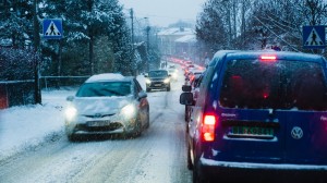 Bilkö på en snöig väg i ett bostadsområde