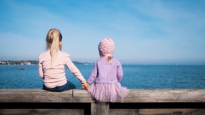 Två flickor på en pir som tittar ut över havet