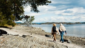 Et eldre par går på tur langs en fjord.