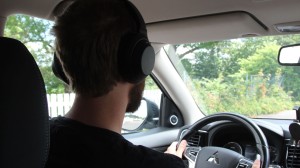Person som kör bil med hörlurar