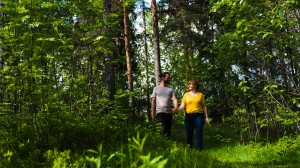 Kvinna och man som vandrar genom grönskande skog