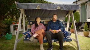 En kvinna och en man som sitter i en hammock och pratar