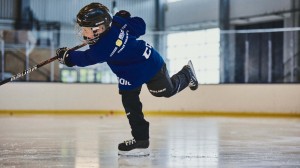 Ett barn som skjuter ett skott på en hockeyrink